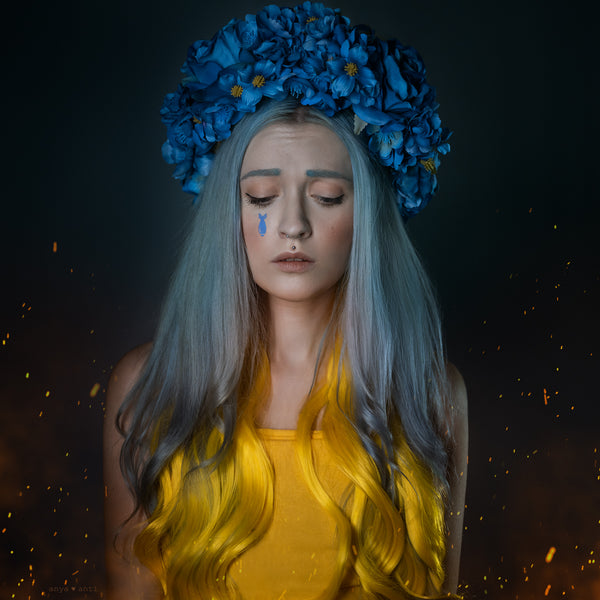 The collaboration print image between Anya Anti & Patricia Barrett Studio, featuring a young woman with a blue flower crown and yellow dress with a sad expression. 